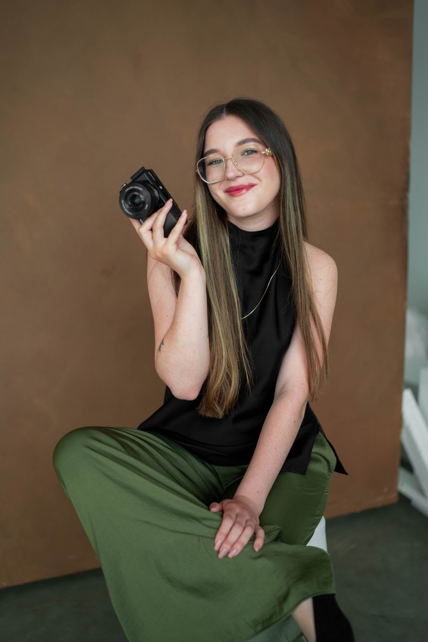 Yaroslava Kuchma, Calgary commercial photographer holding her camera